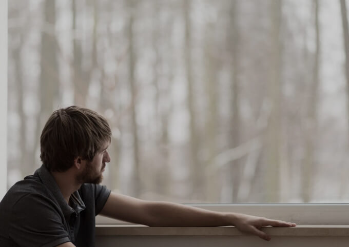 парень смотрит в окно